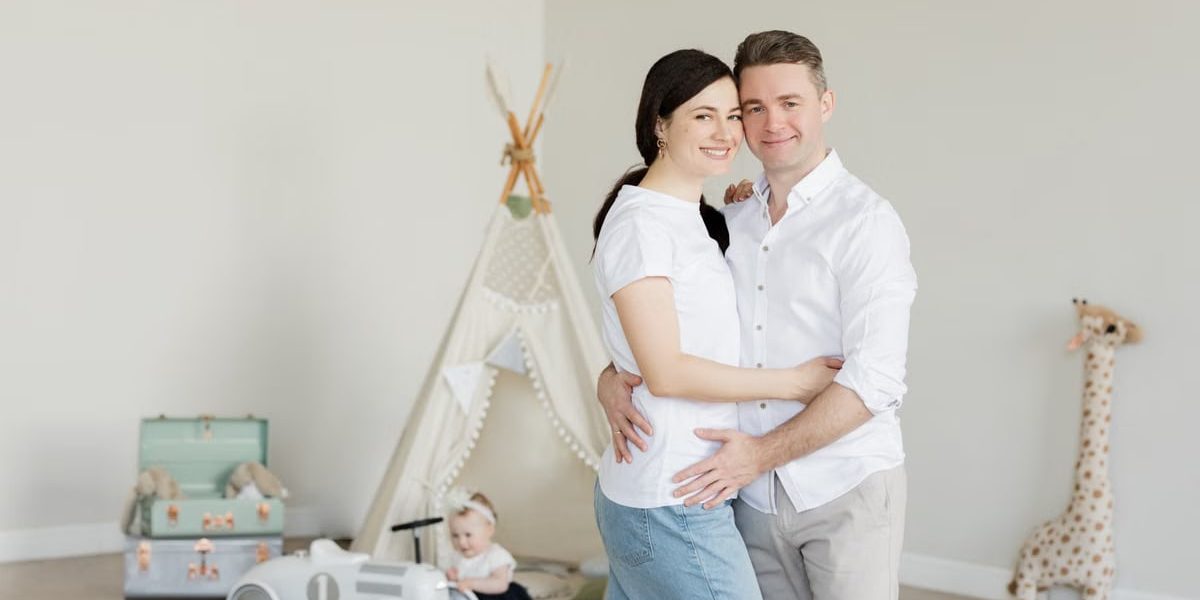 A joyful family with a toddler in a cozy room with playful decor and a teepee.